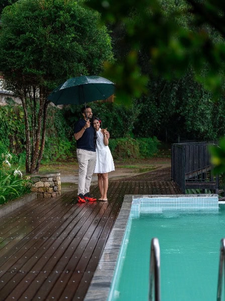 Guests relaxing beside the pool at Blackberry Hills Munnar
